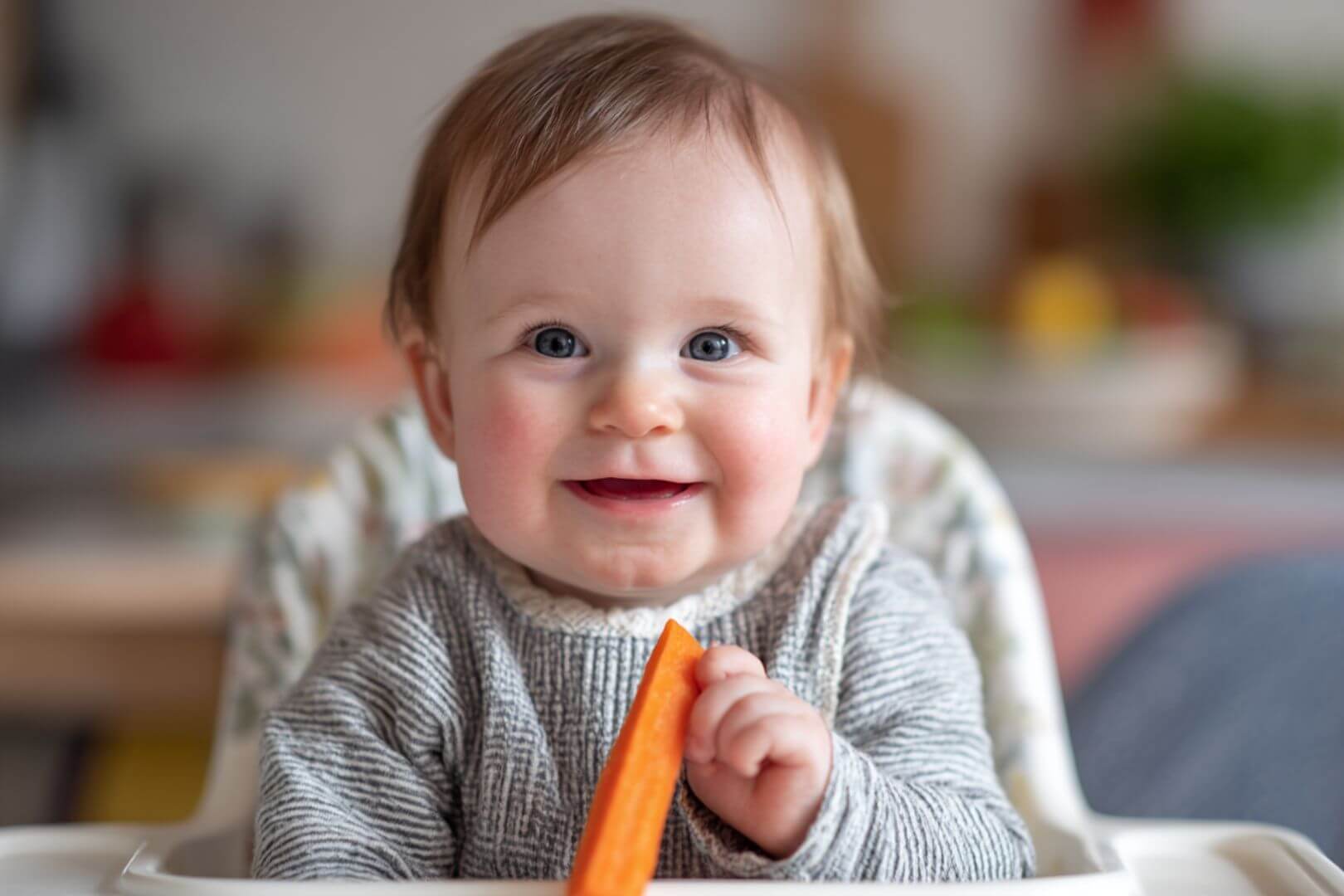 bebé de 6 meses comiendo zanahoria cocida con método Baby-Led Weaning.