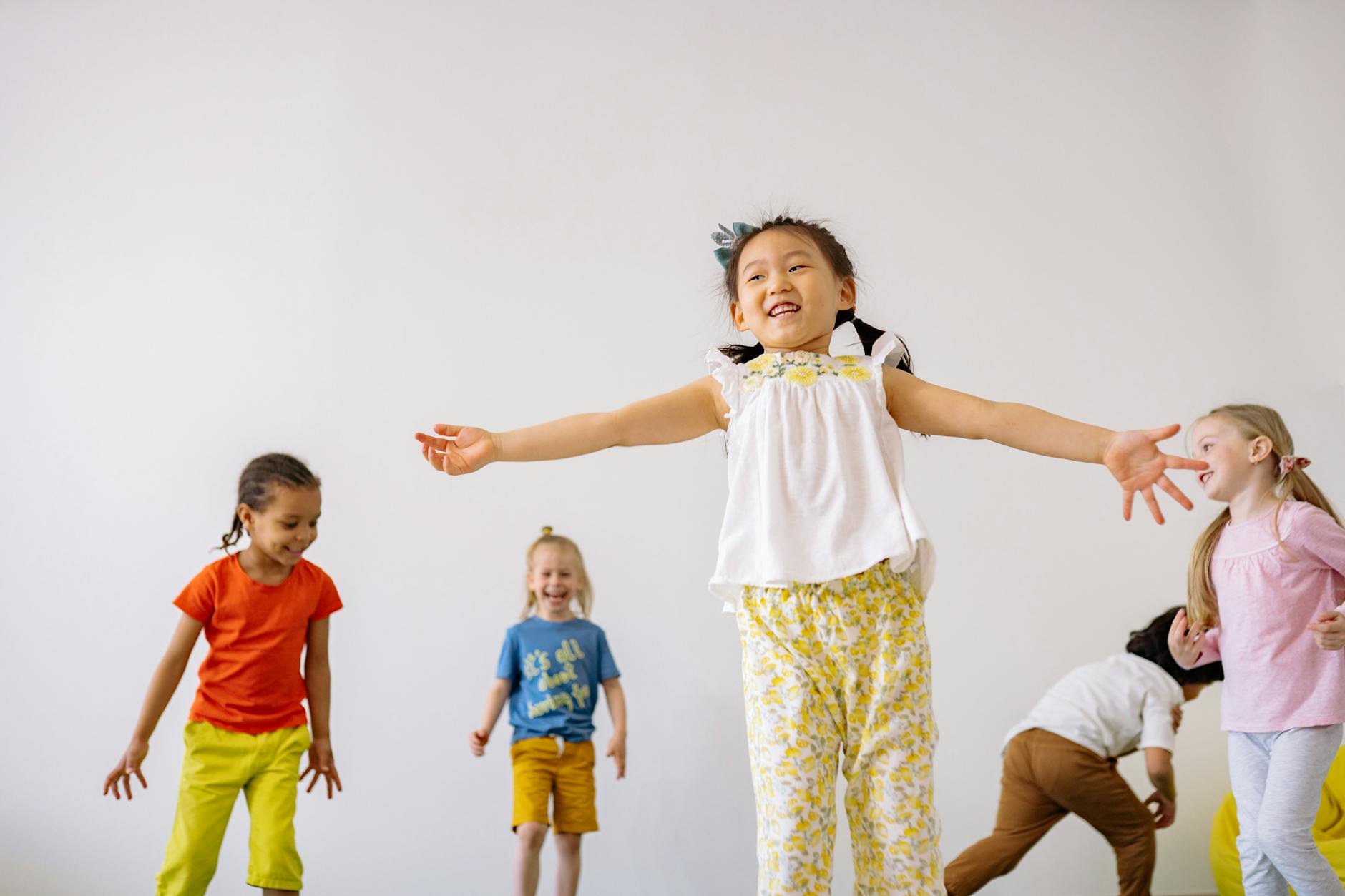 girl in white and yellow floral dress playing with other kids