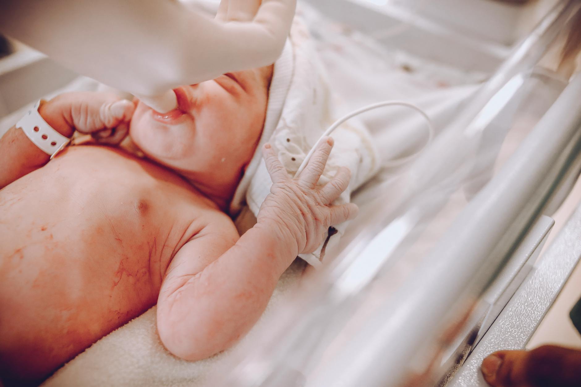 baby lying on white bed