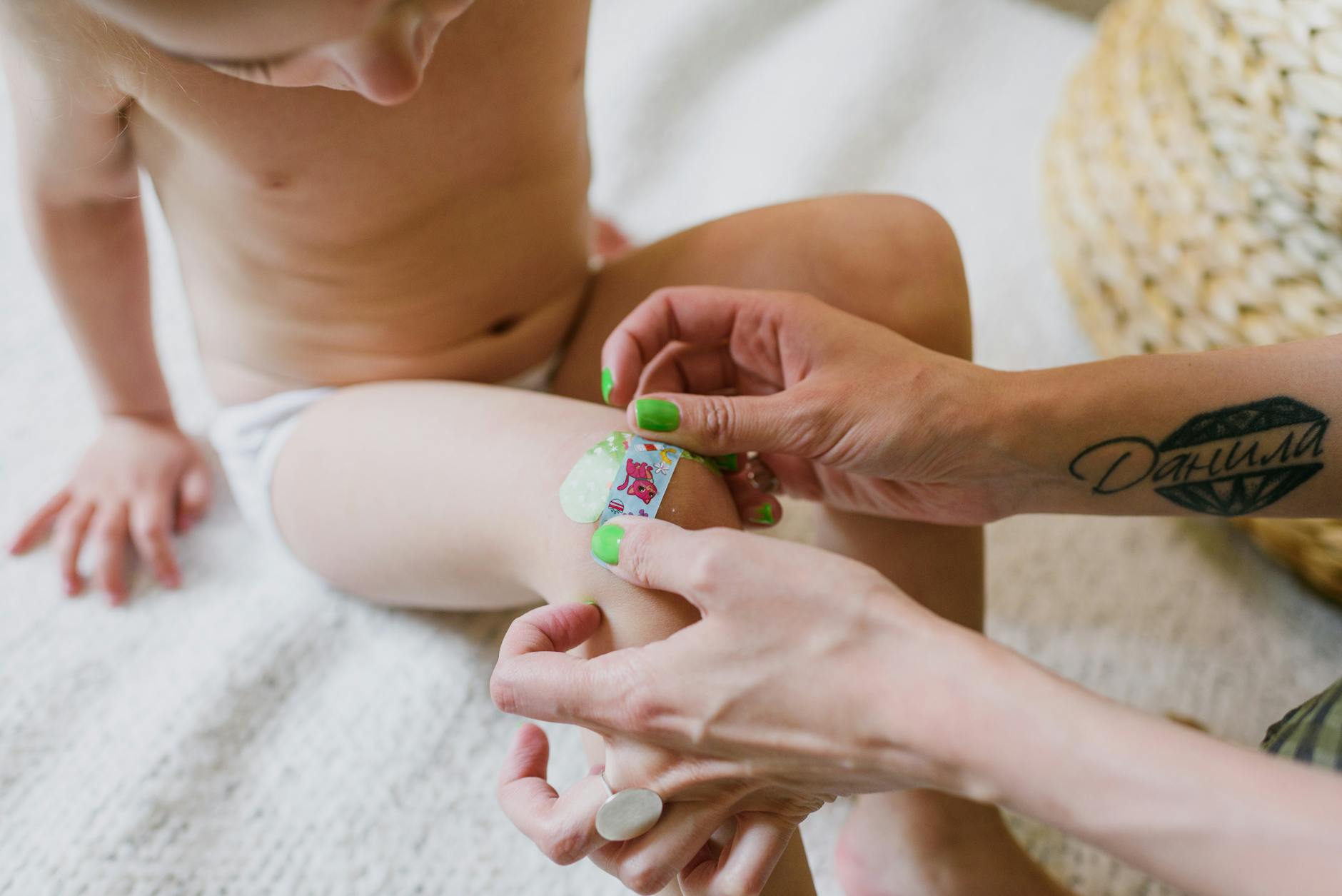 unrecognizable mother sticking sterile patch on kid knee