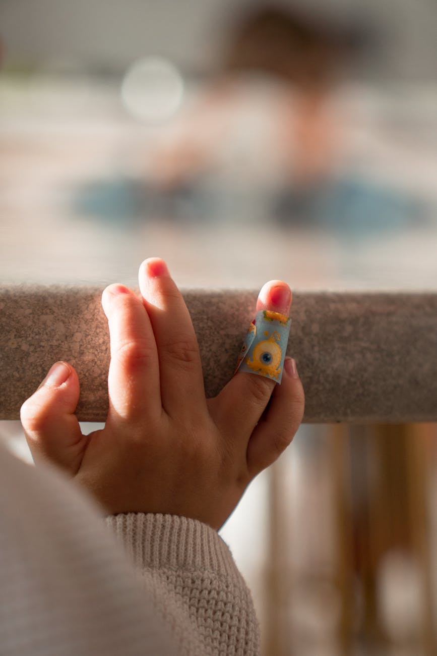 close up photo of baby s hand with bandage