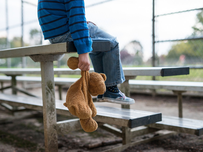 niño triste solo peluche