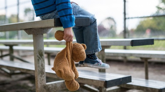 niño triste solo peluche