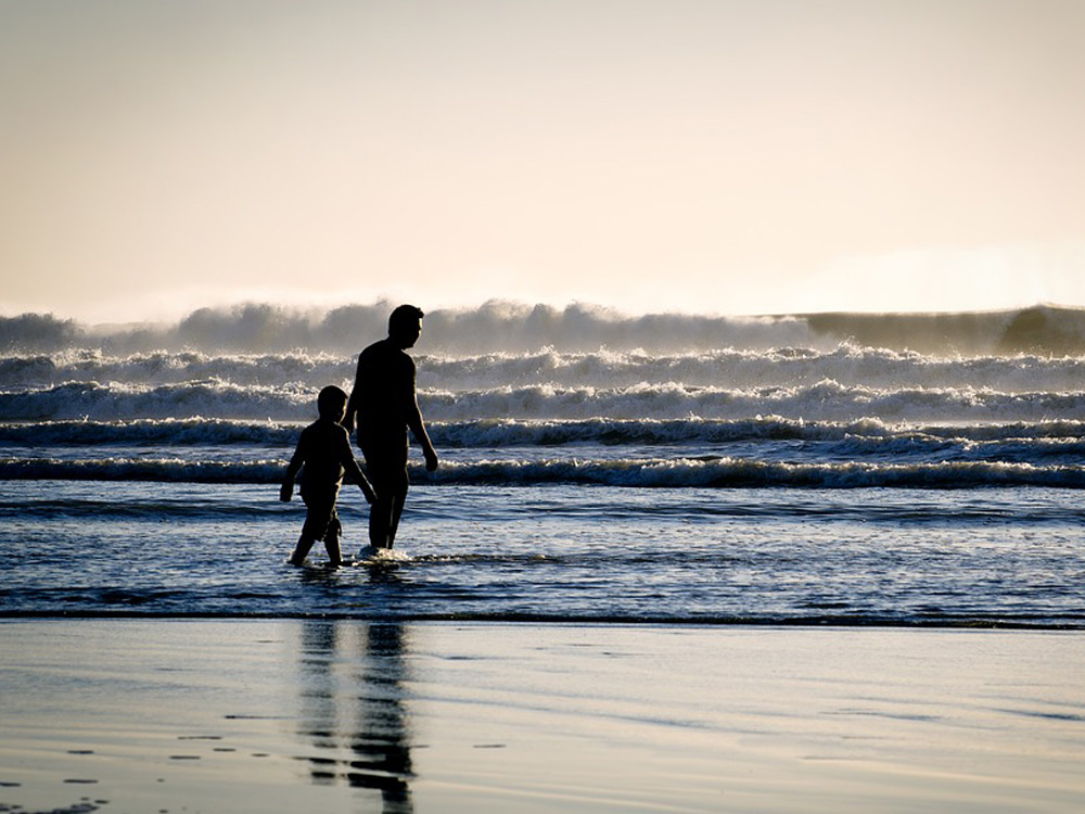 Padre e hijo por las playa hablando