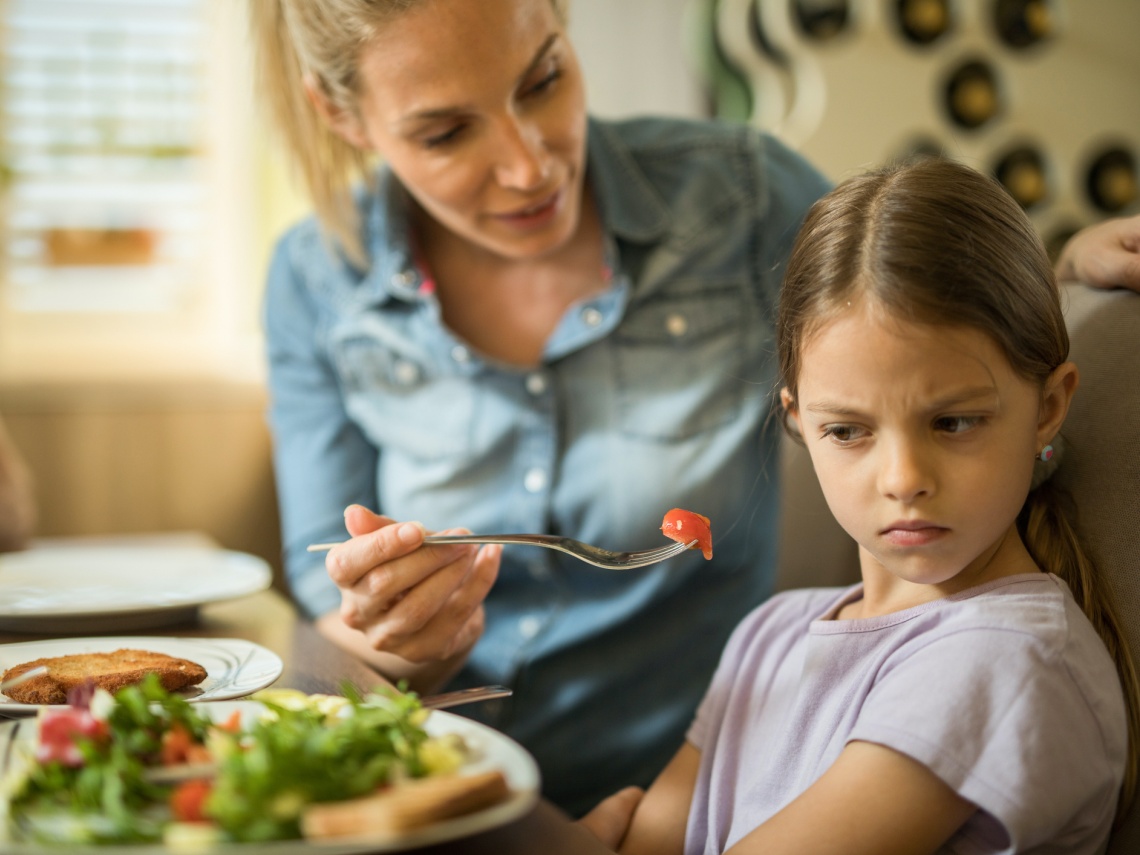 Niña enfadada comiendo