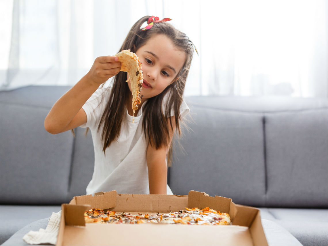 niña comiendo pizza