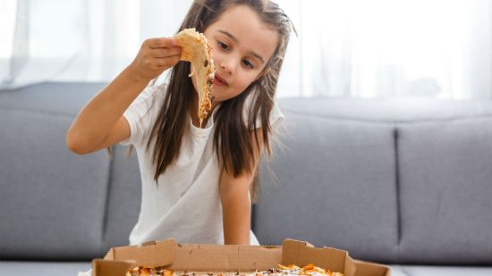 niña comiendo pizza