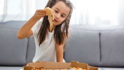 niña comiendo pizza