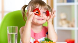 niña jugando con las verduras
