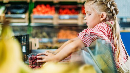 niña comprando en un supermercado