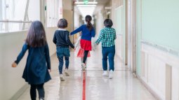 niños y niñas andando por el pasillo del colegio