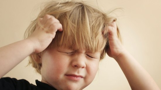 niño quejándose de dolor de cabeza
