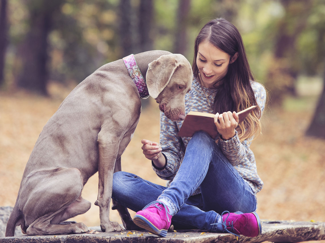 Chica leyendo con un perro