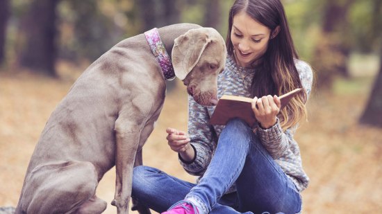 Chica leyendo con un perro