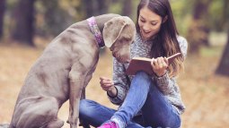 Chica leyendo con un perro