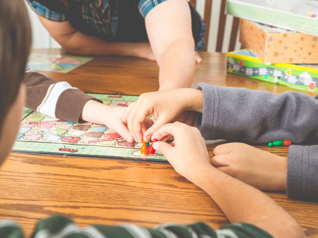 Una familia se entretiene con un juego de mesa.