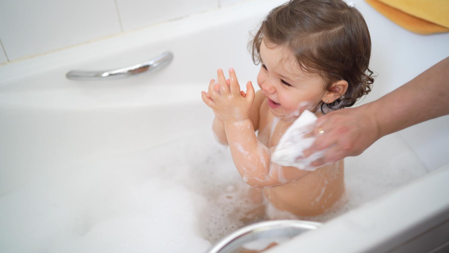 Mamá bañando a su hija con la esponja Babybaño