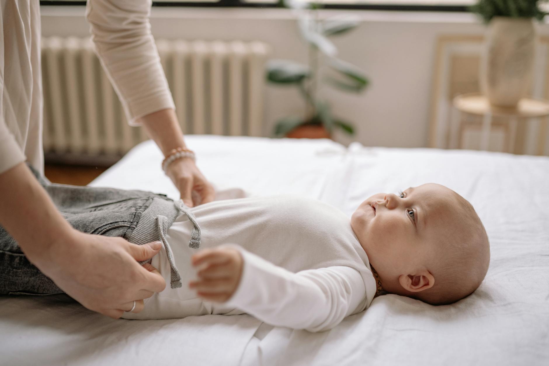 woman dressing a baby