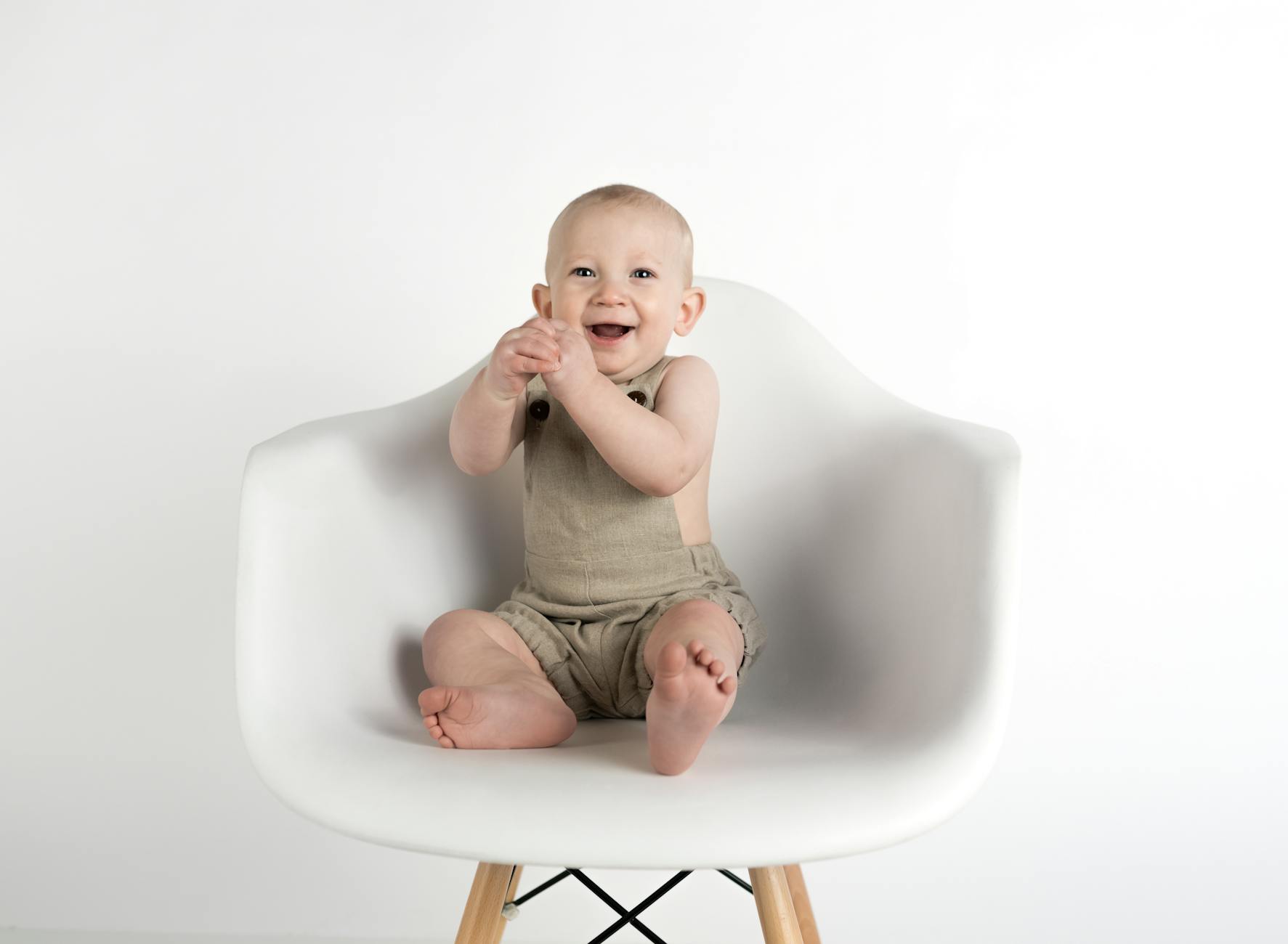 baby sitting on white chair