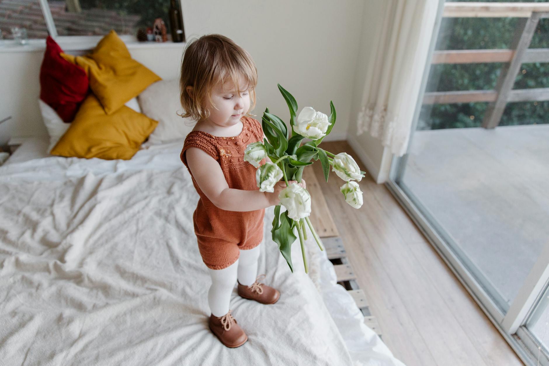 photo of kid holding flowers