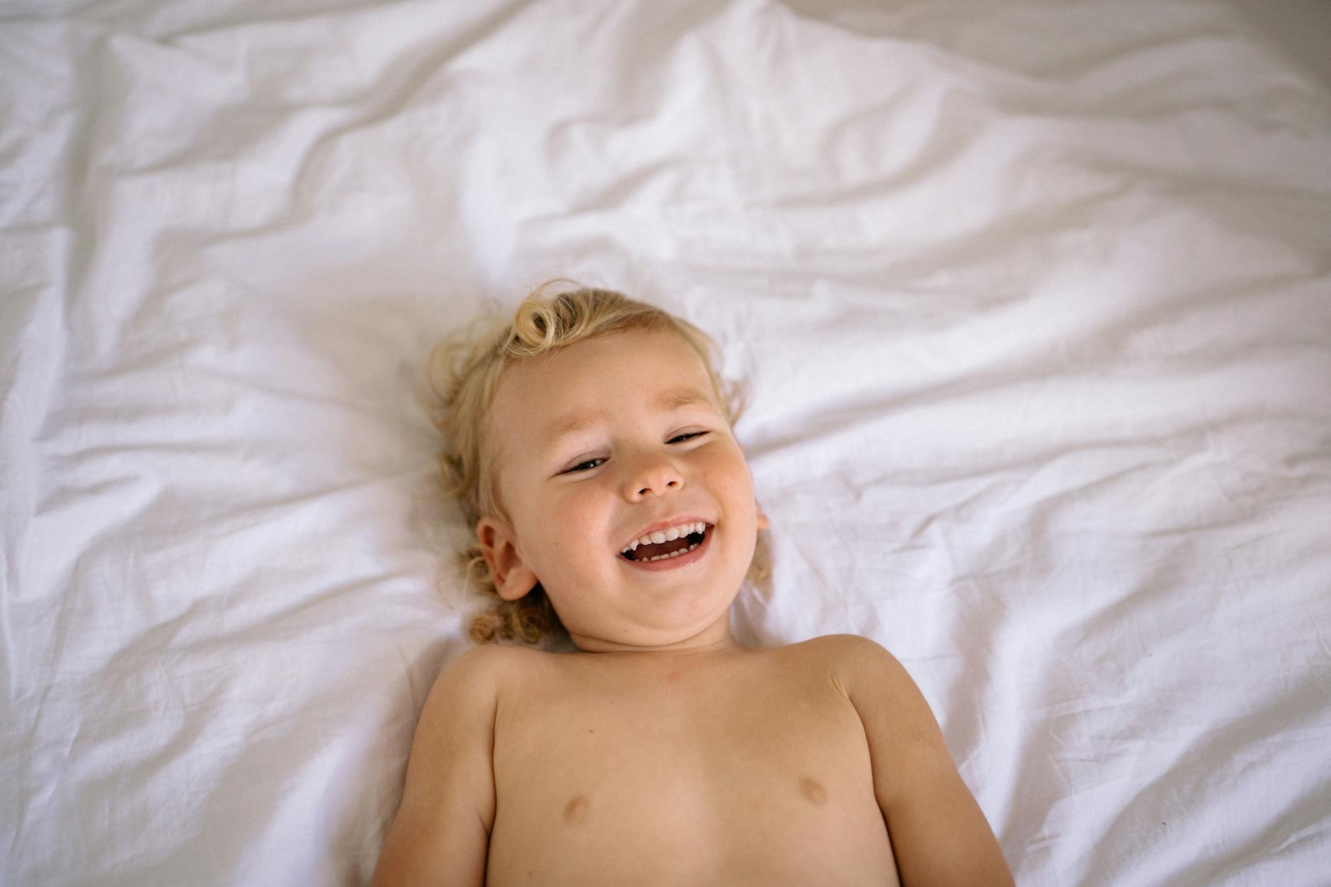 smiling baby girl on a bed