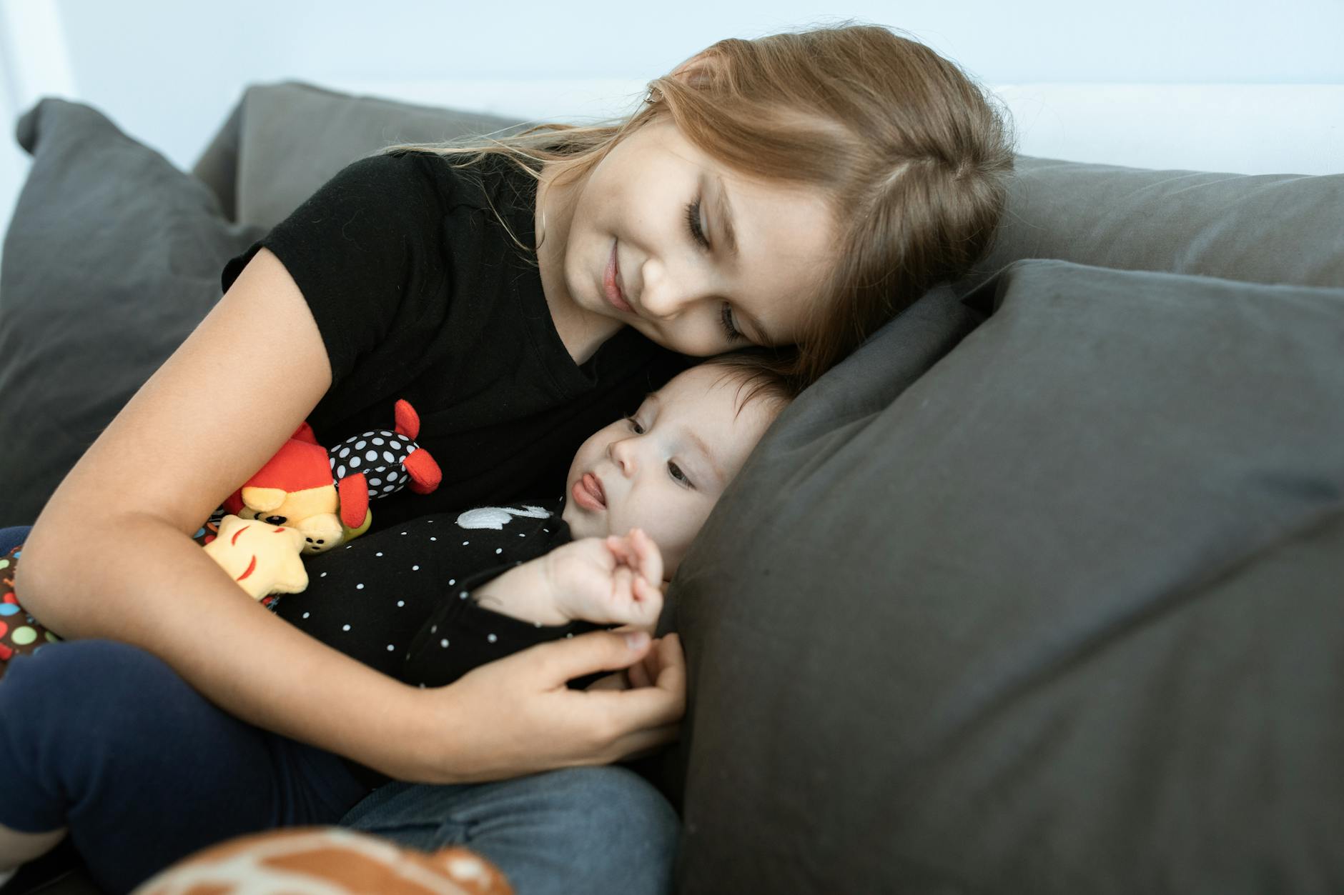 girl in black crew neck t shirt lying on black sofa