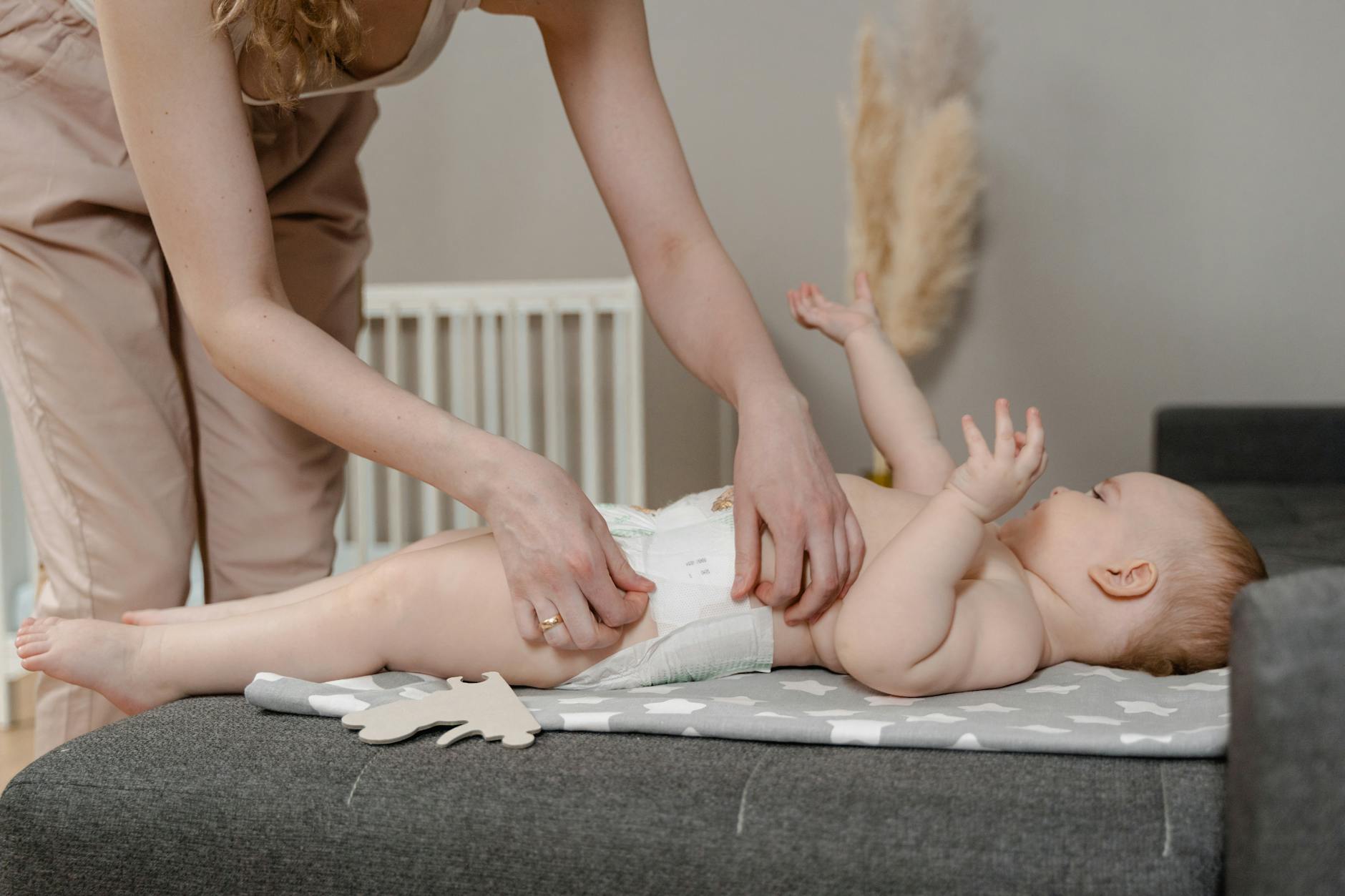a mother changing a diaper of a baby