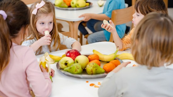 Niños comiendo fruta