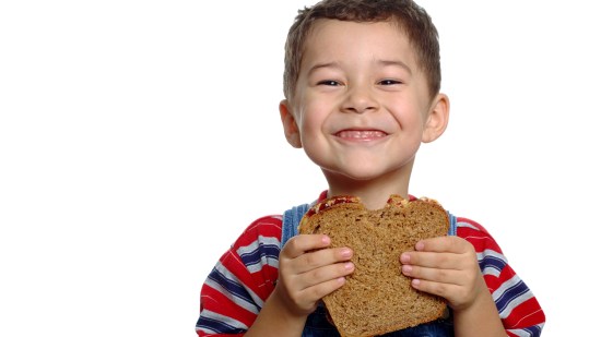 Niño comiendo un sándwich integral