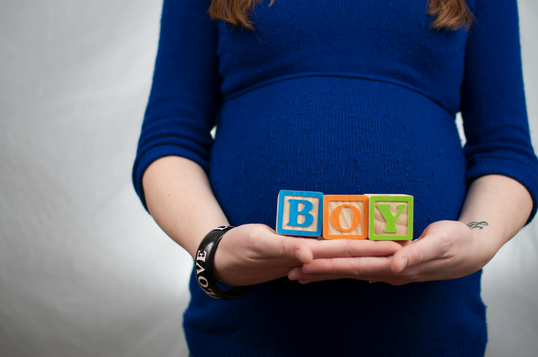 lady wearing lbue long sleeve dress and holding boy piece box
