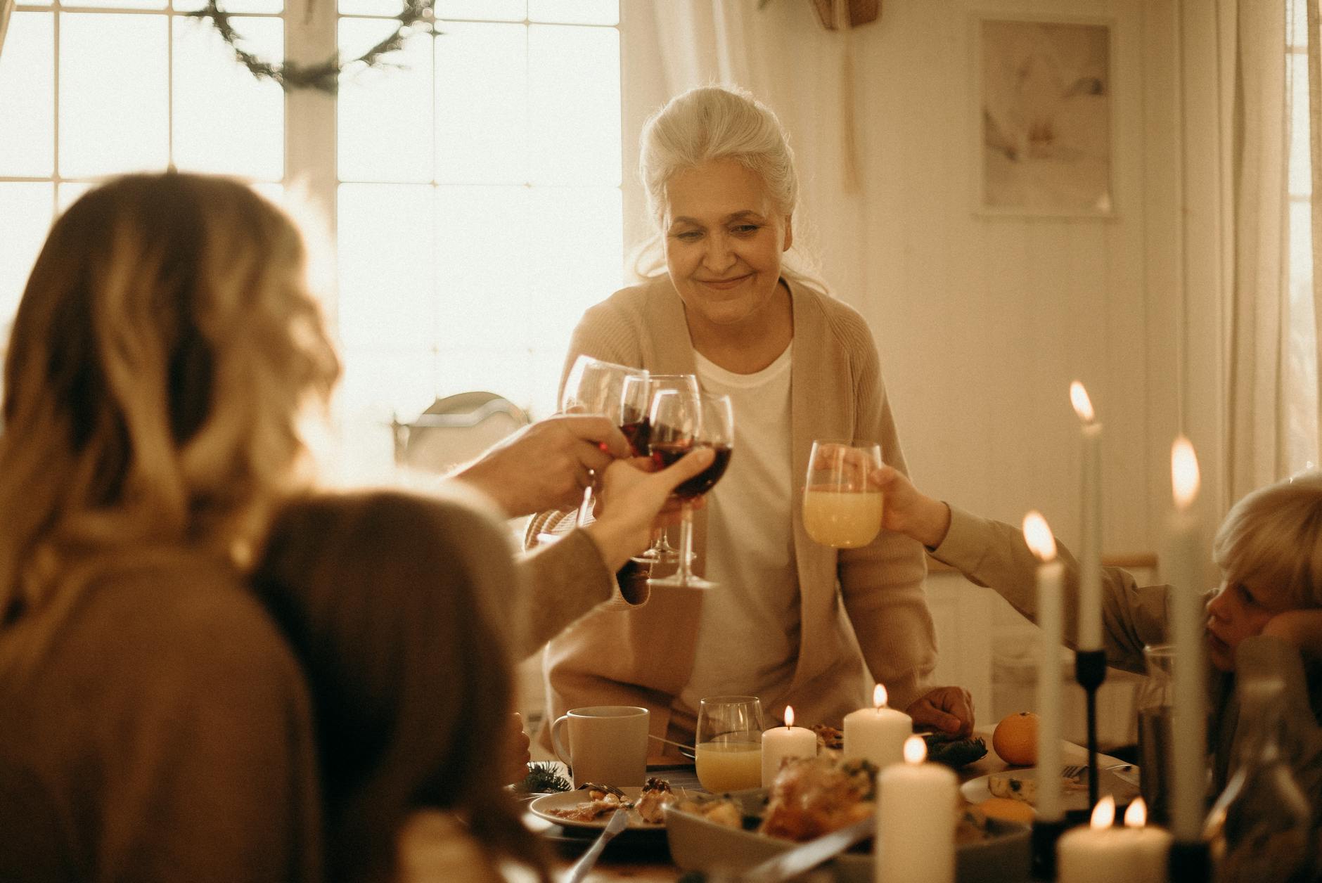 woman on gray cardigan standing near table doing cheers