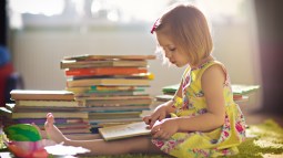 Niña en su habitación leyendo