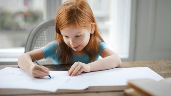 Niña escribiendo con colores