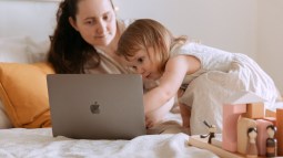 Niña viendo dibujos con su madre