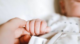 Madre cogiendo la mano de su bebé recién nacido