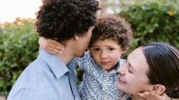 Padres abrazan a su hijo