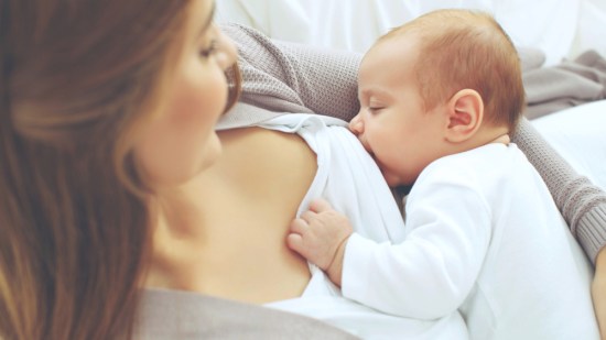 Mujer dando de comer a su hijo