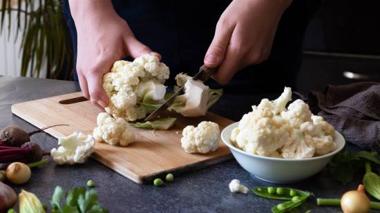 Mujer cortando coliflor
