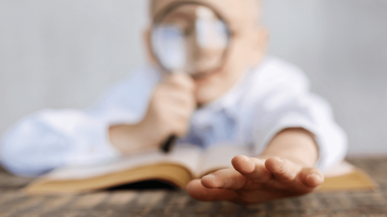 Niño con lupa leyendo