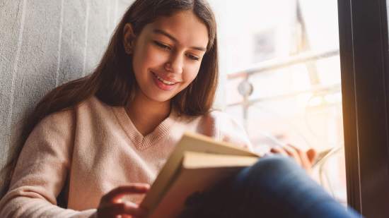 Adolescente leyendo un libro de poesía