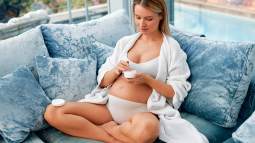 Mujer embarazada aplicándose crema facial