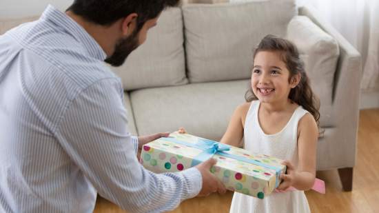 Un hombre entregando un regalo a una niña