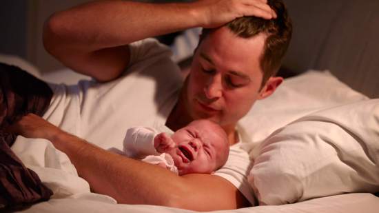 Papá intentando dormir a su bebé