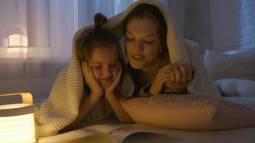 Madre leer con su hija antes de dormir