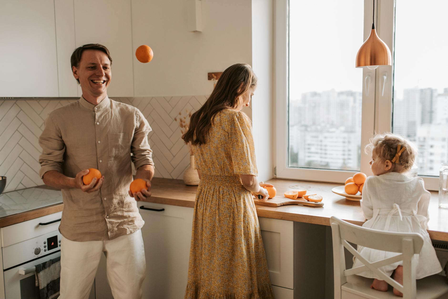 a man joggling the orange fruits
