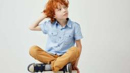 beautiful-ginger-boy-with-curly-hair-freckles-casual-clothes-holding-hand-head-looking-aside-with-relaxed-expression