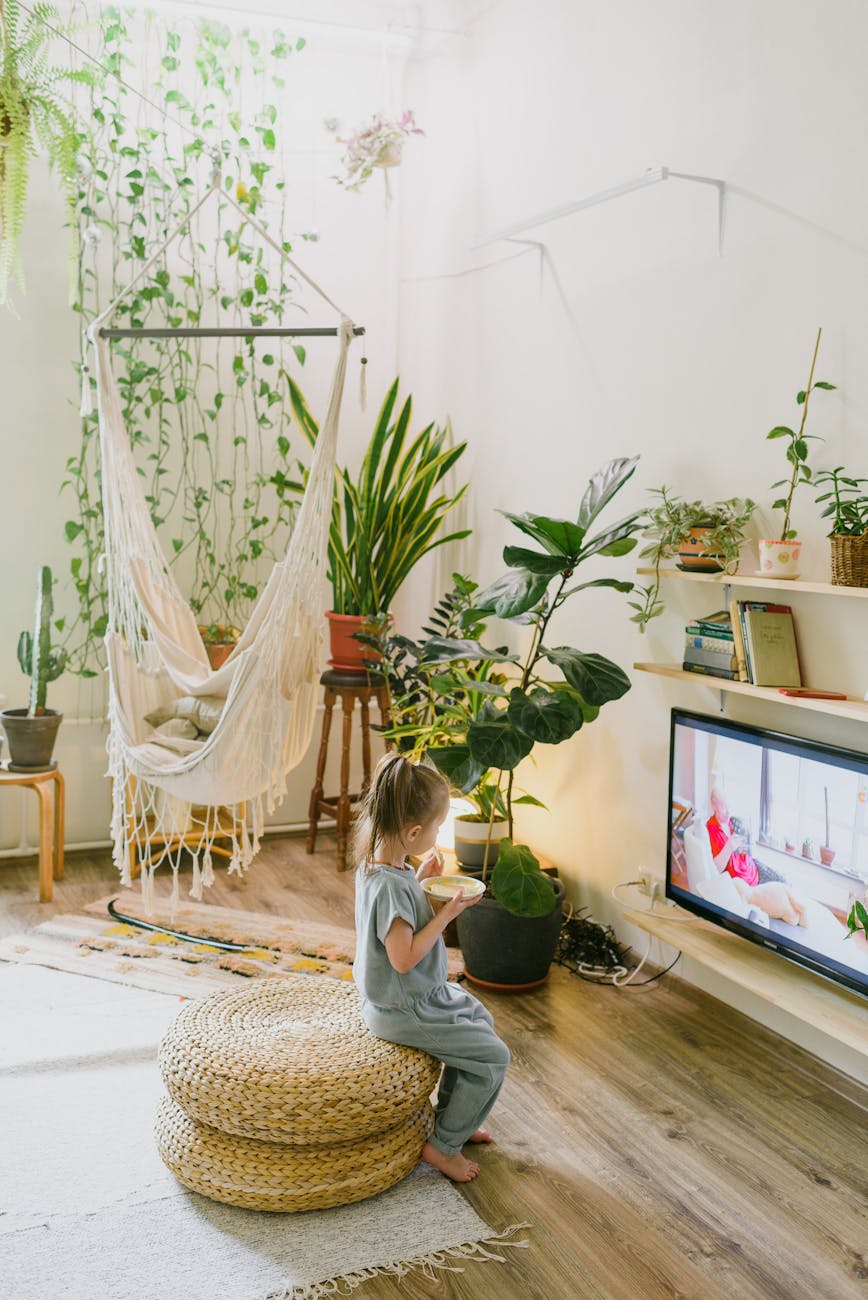 unrecognizable girl eating and watching tv in living room