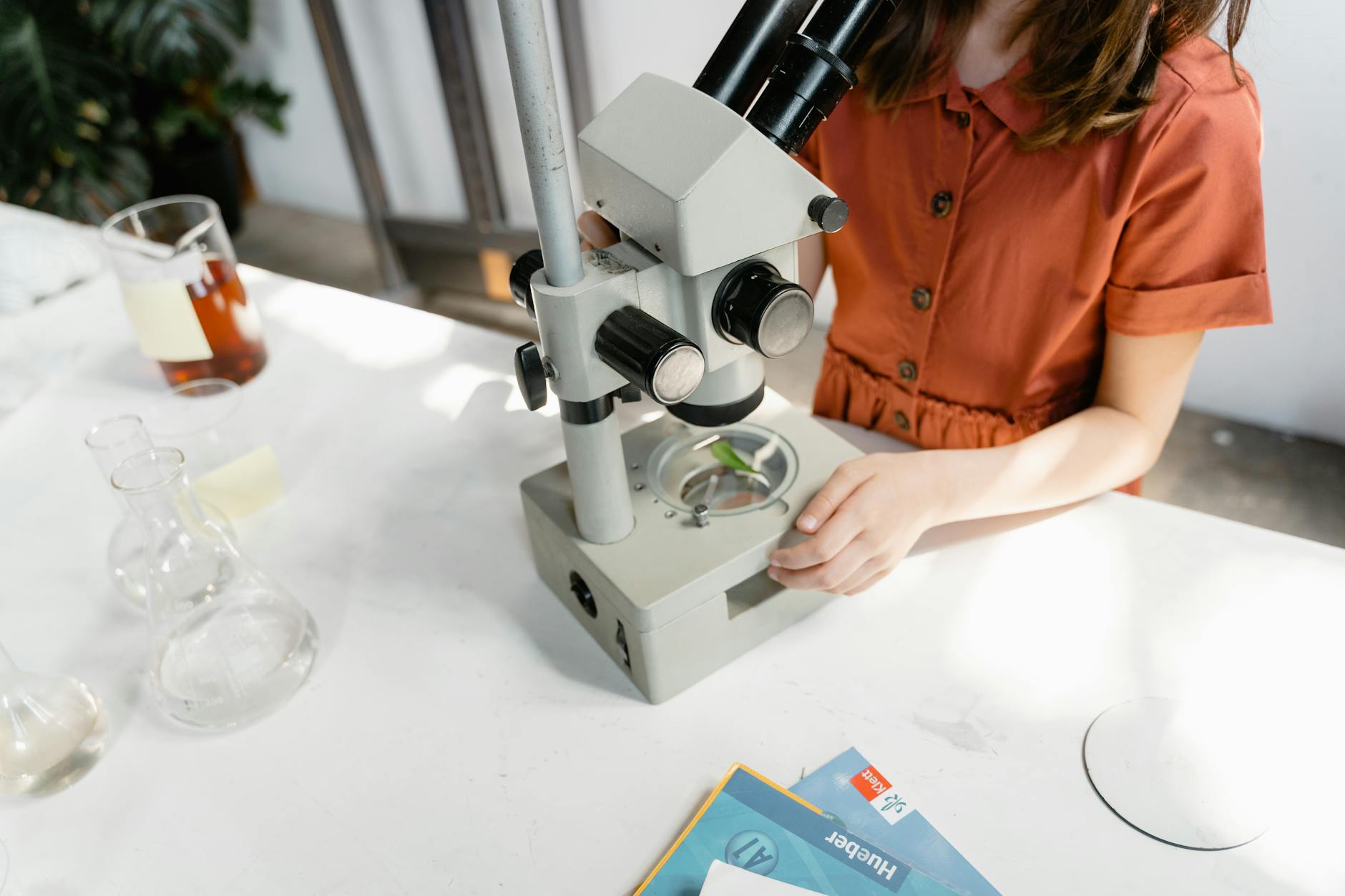 a girl doing an experiment using a microscope
