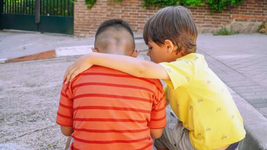 Un niño, consolando a un amigo