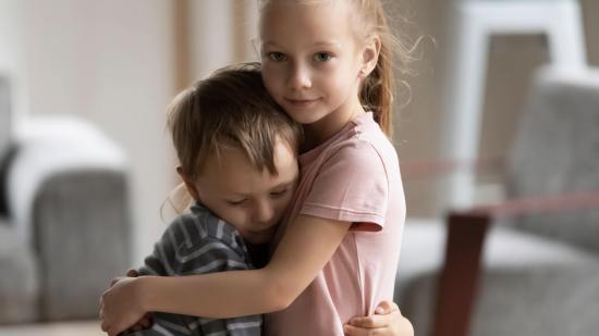 Una niña abraza a su hermano, triste